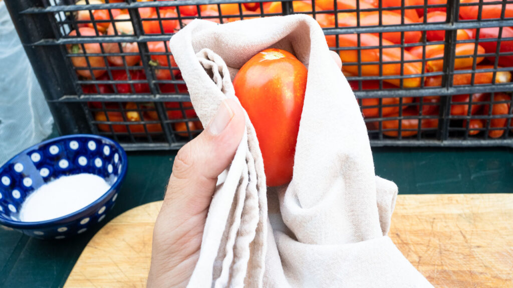 Cleaning tomatoes with white cloth